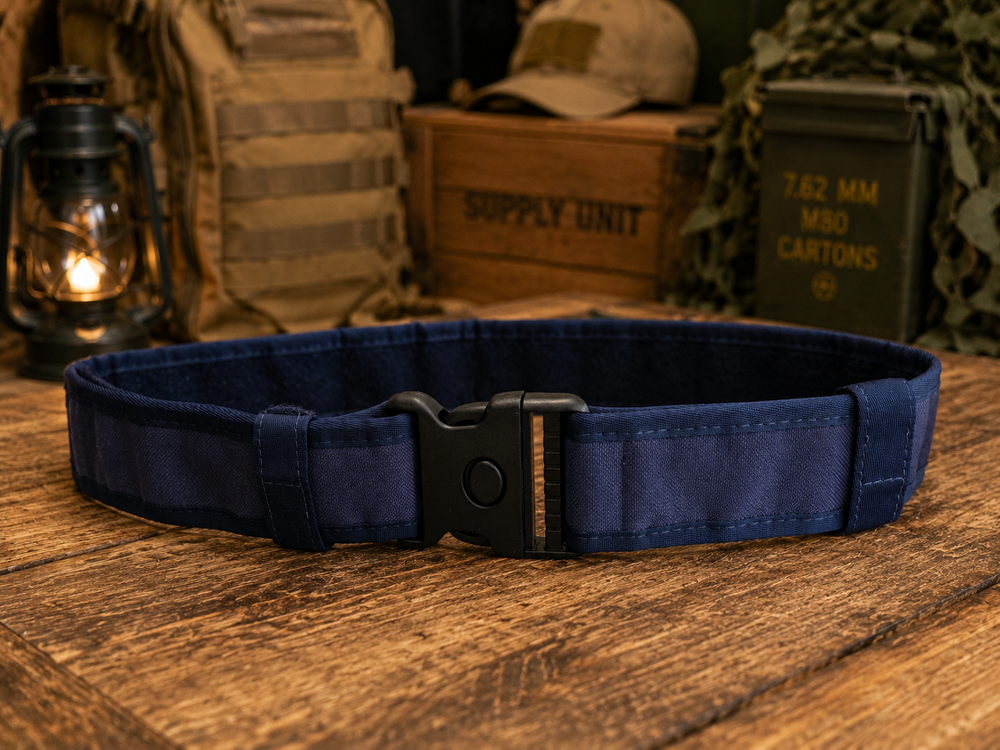Cinto tático azul escuro com fivela preta sobre mesa de madeira