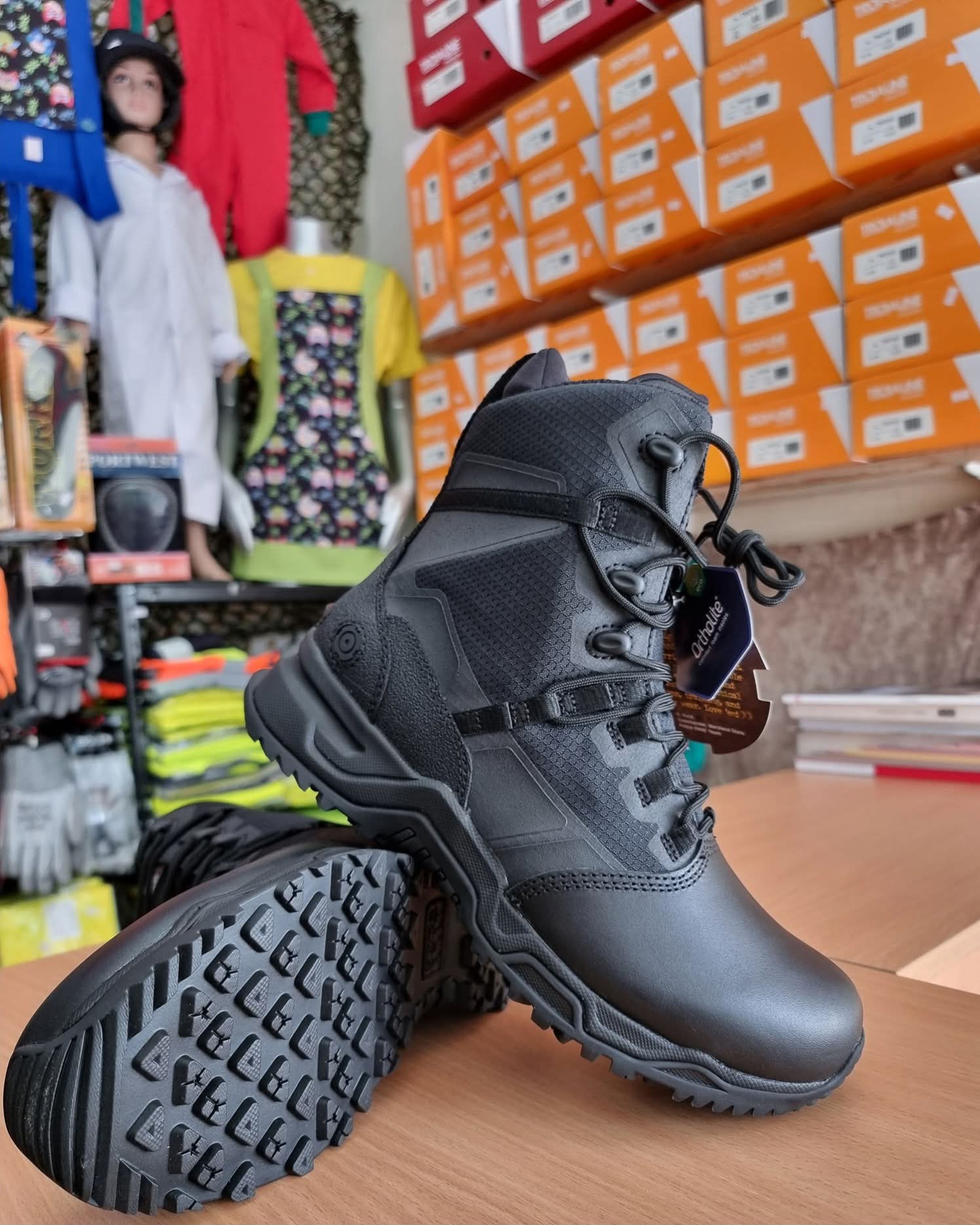 Bota preta resistente com sola antiderrapante e etiqueta Ortholite em loja