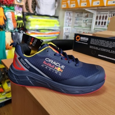 Ténis desportivo azul escuro com o logótipo Red Bull Racing sobre balcão de madeira