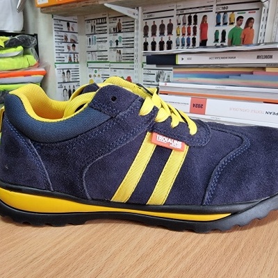 Ténis desportivo azul escuro com detalhes amarelos e etiqueta TROJALINE