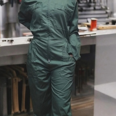 Macacão verde de trabalho com bolsos em ambiente industrial