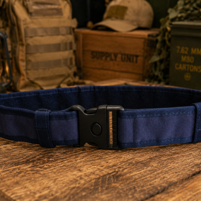 Cinto tático azul escuro com fivela preta sobre mesa de madeira