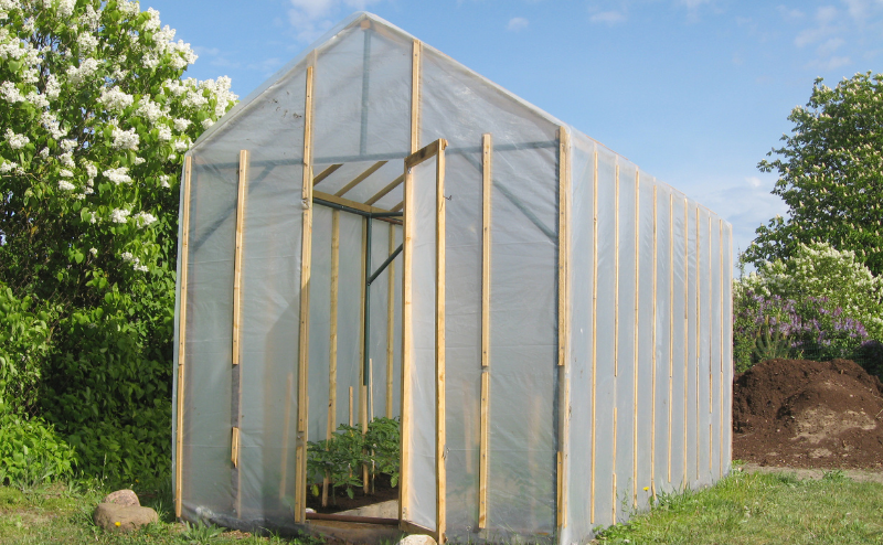 Estufa de madeira com plástico transparente em ambiente exterior