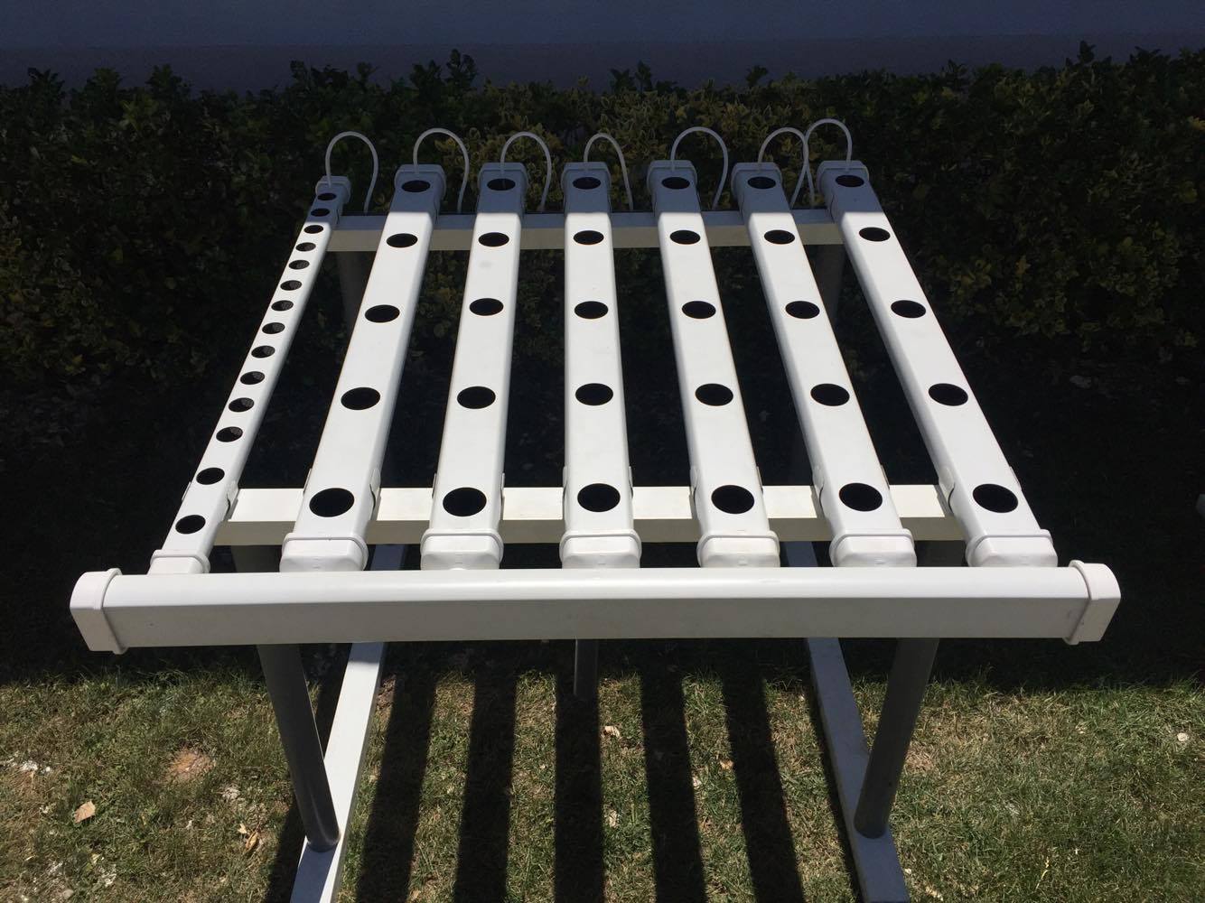 Estrutura metálica branca com barras perfuradas ao ar livre