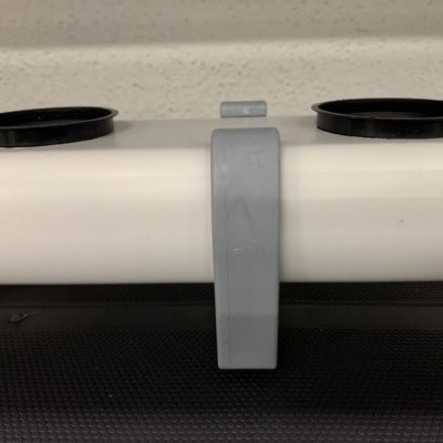 Suporte branco com grampo cinza e peças pretas nas extremidades