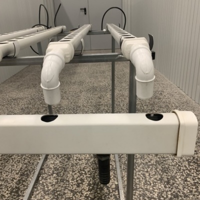 Sistema de tubos de PVC brancos instalados sobre estrutura metálica em ambiente fechado