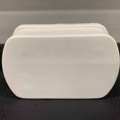 Três caixas brancas empilhadas sobre superfície preta com fundo cinzento