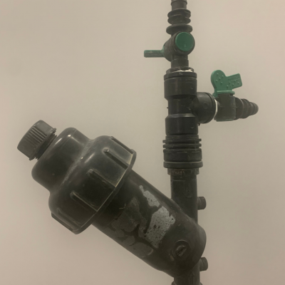 Sistema de tubos e válvulas de plástico preto com válvulas verdes e filtro cilíndrico