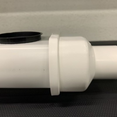 Tubo de plástico branco com tampas preta e branca sobre superfície escura