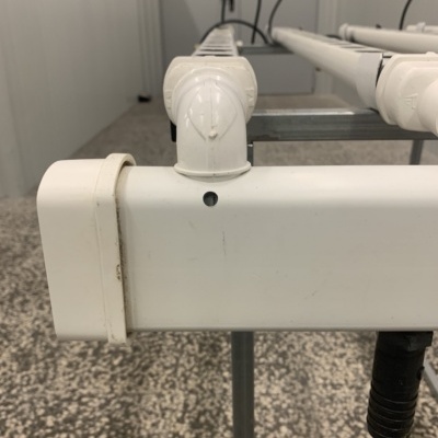 Estrutura metálica branca com tubos e conectores em ambiente industrial