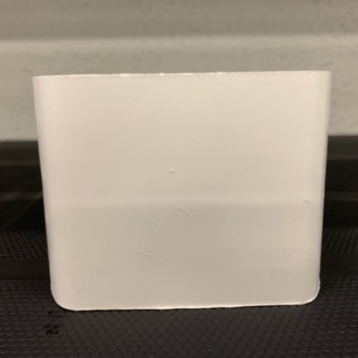 Caixa retangular branca sobre superfície preta texturada