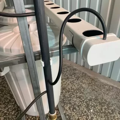 Régua elétrica branca com tomadas e cabos pretos em estrutura metálica cinzenta