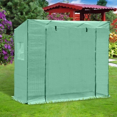 Tenda de armazenamento verde claro num jardim ao lado de flores e árvore