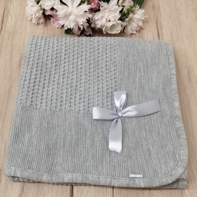 Manta cinzenta de malha com padrão texturizado e laço