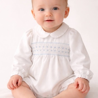 Bebé com macacão branco de bordado azul