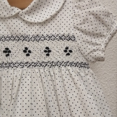 Vestido branco de bebé com mini bolinhas negras e bordado floral
