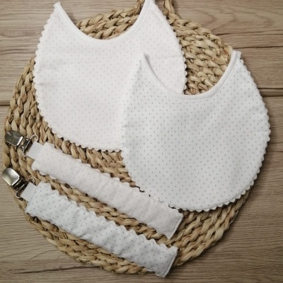 Conjunto de dois babetes brancos com bolinhas e duas fitas brancas com presilhas em base de ráfia