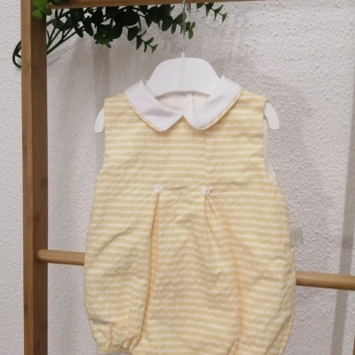 Body bebé amarelo às riscas com gola branca pendurado em cabideira de madeira