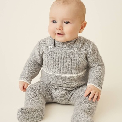 Bebé vestindo roupa de malha cinzenta com padrão no peito e pés fechados
