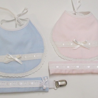 Dois babetes de bebé azul claro e rosa claro com renda e fita, dois prendilhos para chupeta combinando