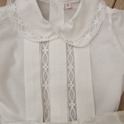 Blusa branca de criança com gola de renda e detalhes frontais em renda