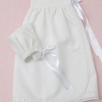 Conjunto branco para bebé com saia e gorro em tecido leve com detalhes em bordado ponto inglês e fita de cetim