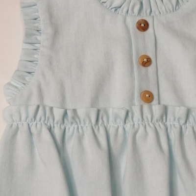 Vestido azul claro para criança com botões de madeira e detalhes franzidos