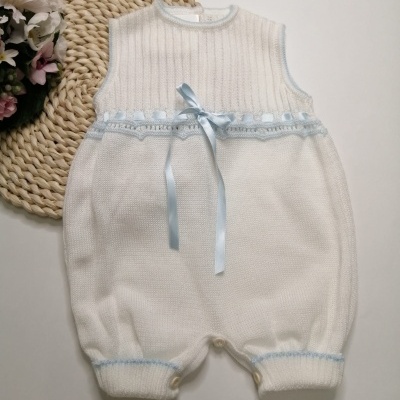 Macacão de bebé branco com laço azul e botões em fundo branco