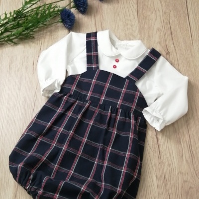 Conjunto de roupa de bebé com body branco e vestido xadrez azul escuro e vermelho
