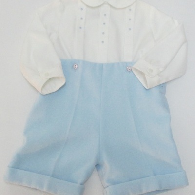 Roupa de bebé branca e azul claro com gola redonda e botões rosa