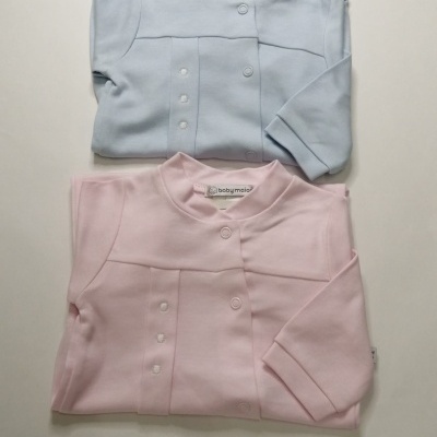 Peças de roupa de bebé azul clara e rosa dobradas com botões e gola alta
