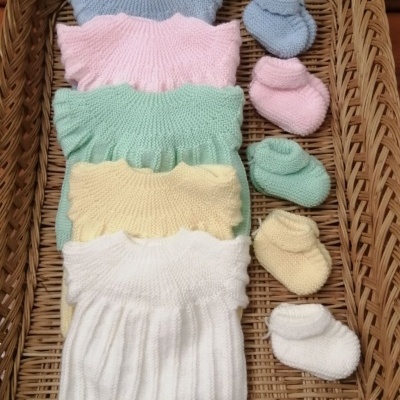Conjunto de roupa de bebé em malha colorida numa cesta de verga