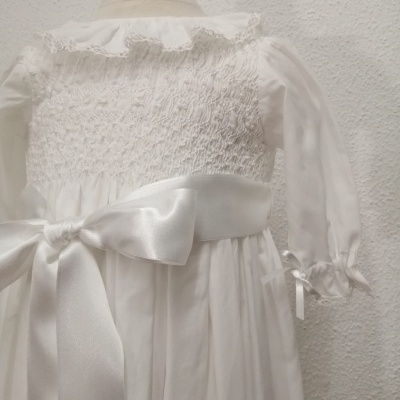 Vestido branco de criança com mangas transparentes e laço em cetim