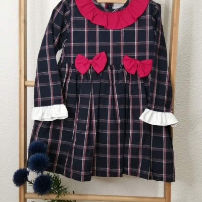 Vestido xadrez azul escuro com detalhes vermelhos e brancos pendurado