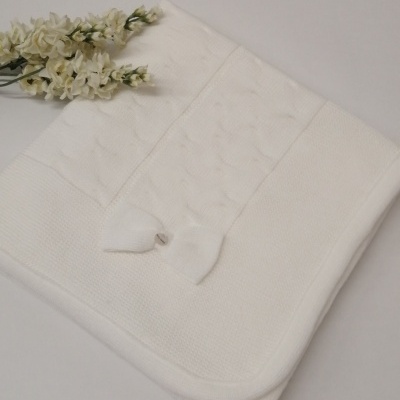 Manta branca de bebé com laço e padrão texturizado