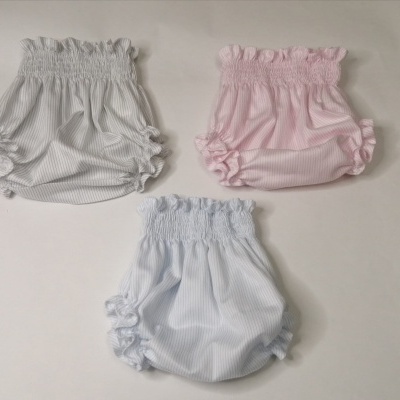 Três fraldas de tecido nas cores cinza, rosa e azul claro com riscas finas