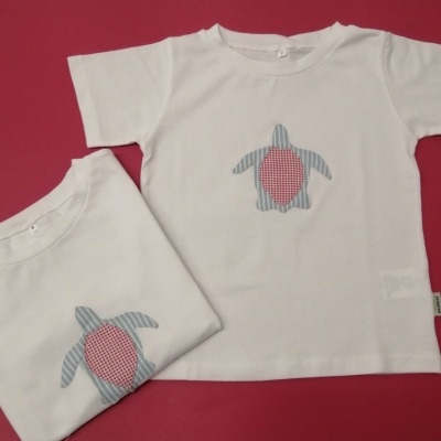 Duas t-shirts infantis brancas com aplicação de tartaruga azul e vermelha