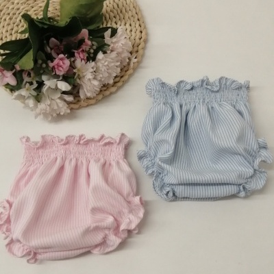 Peças de roupa de bebé riscas rosa e azul com folhos, fibra natural e flores decorativas