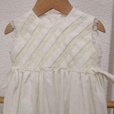 Vestido infantil branco com renda e cabide de madeira
