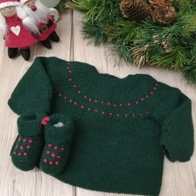 Camisola e meias de malha verde com pontos rosa junto a decoração natalícia de duendes e coroa de pinhas