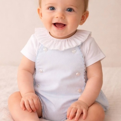 Bebé sorridente com roupas claras sentado