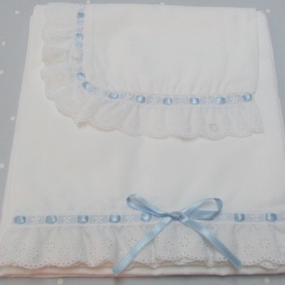 tecidos brancos com bordados em renda e fita azul