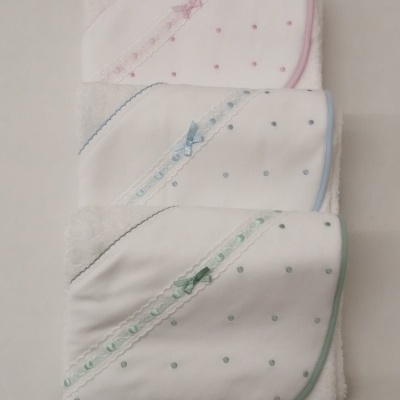 Três toalhas de banho brancas com capuz e detalhes em rosa, azul e verde