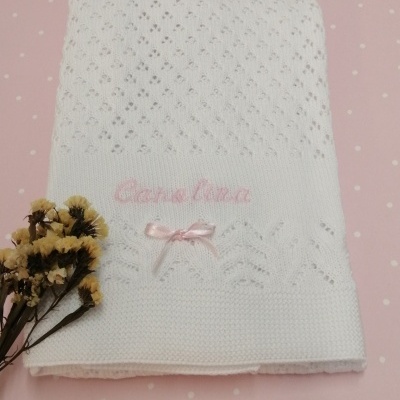Manta branca de malha rendada com bordado rosa e laço cor-de-rosa