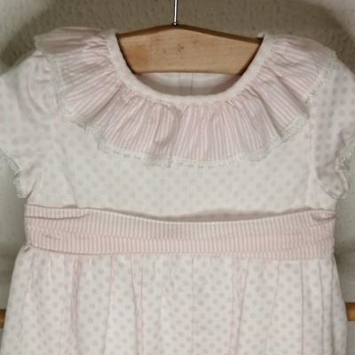 Vestido de bebé branco com pontos rosa, gola com folhos e faixa rosa às riscas