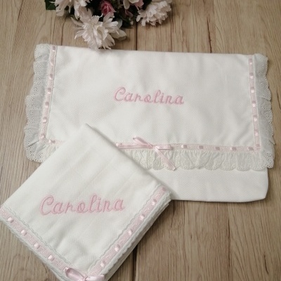 Toalhas brancas bordadas com o nome Carolina e detalhes em renda e fita rosa