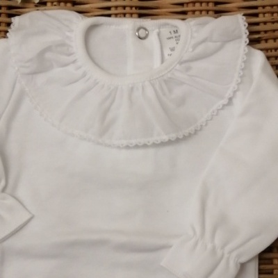 Camisola de bebé branca com gola redonda e detalhes em renda, botão metálico, e etiqueta de tamanho 1M