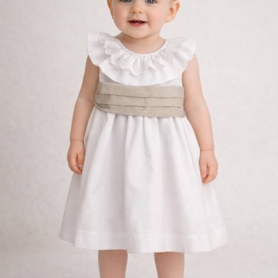 Menina bebé com vestido branco e faixa bege