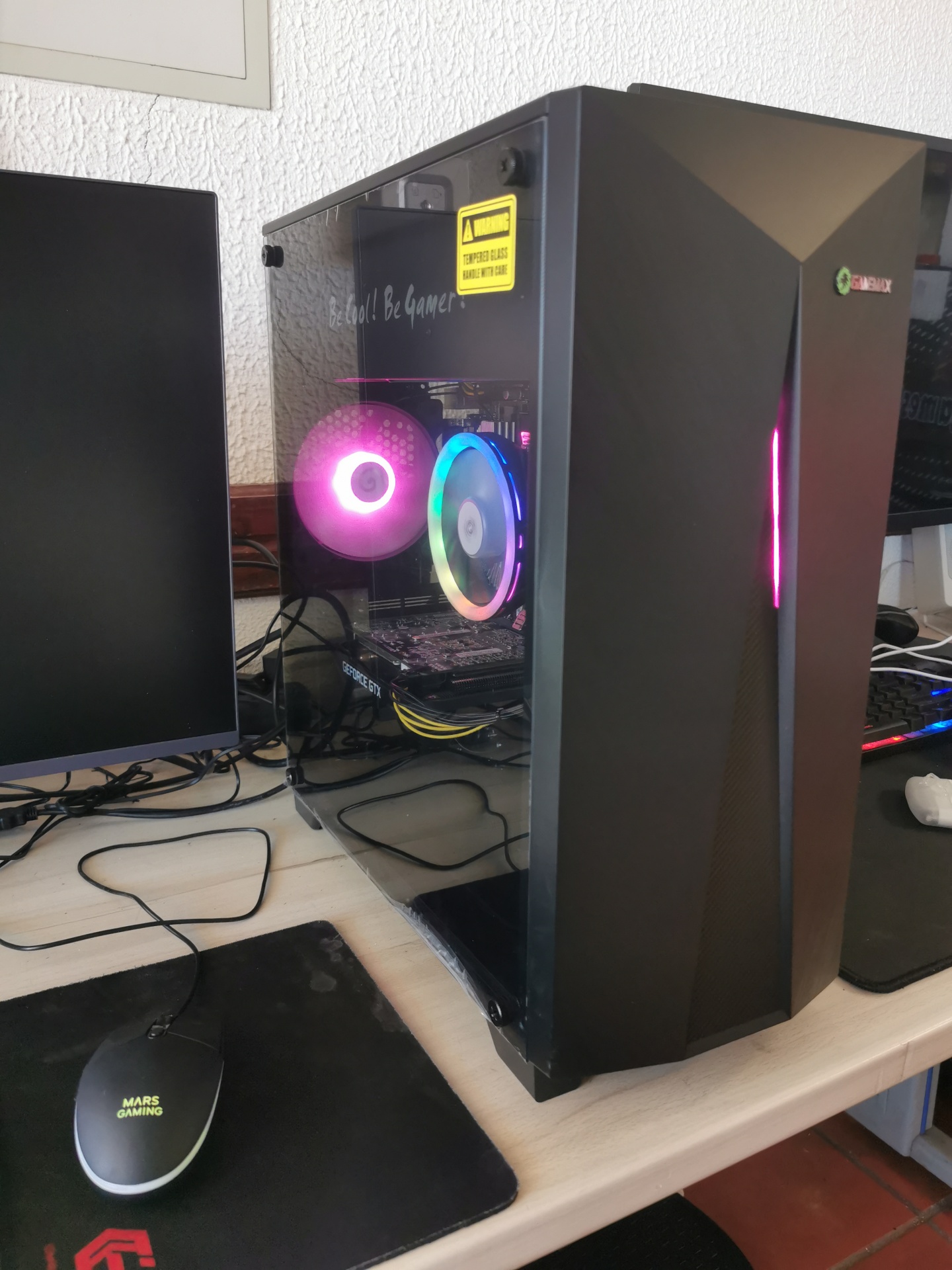 Desktop gaming mA4G R37 Computador desktop preto com vidro temperado e ventoinhas RGB numa secretária com rato e monitor