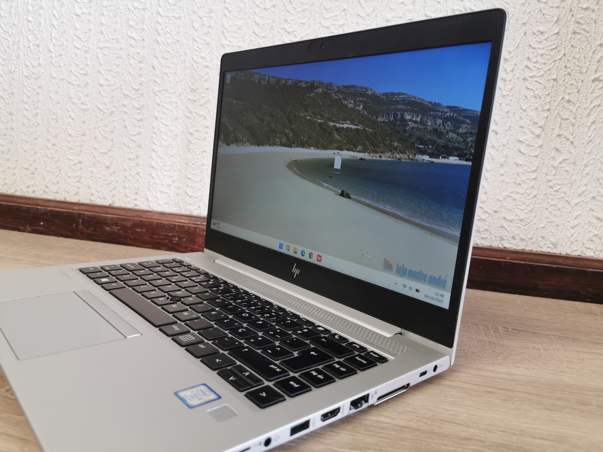HP Elitebook 840 G5 - Intel Core i5 - 8GB ram - SSD 256GB - Windows 11 PRO Computador portátil HP prateado com ecrã ligado mostrando paisagem de praia.